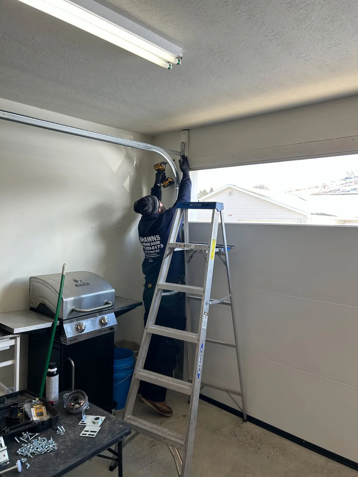 New garage door installation on stone accent home in winter